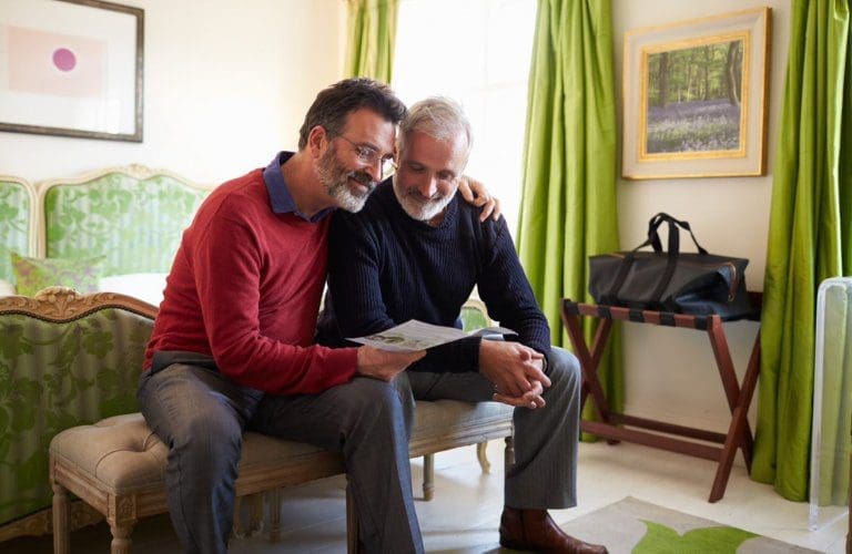 A couple made up of two men sitting down together at home